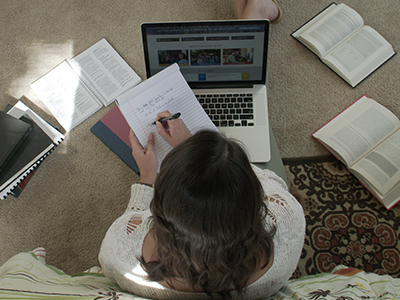 An overhead photo of an online college student learning at home.