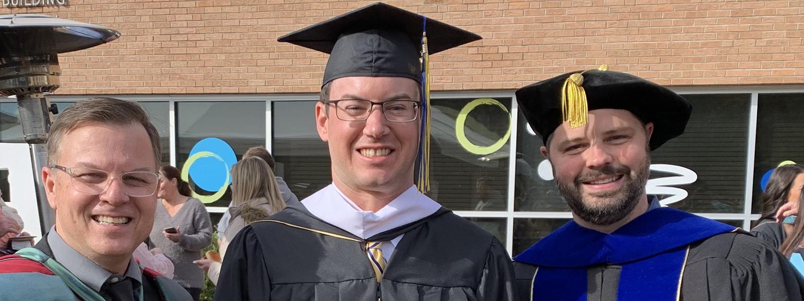 Dr. Ryan Klejment-Lavin (right) poses with James Thompson (center) and Intercultural Studies Dean Dr. Ed Smither after commencement. Klejment-Lavin served as Thompson's advisor for his online M.A. in Intercultural Studies. 