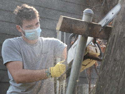 Aden Corley, a freshman in the Bible Teaching program, handles a saw during clean up in Lake Charles.