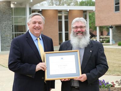 Dr. John Crutchfield (right) is presented with the Excellence In Teaching award by CIU president Dr. Mark Smith.