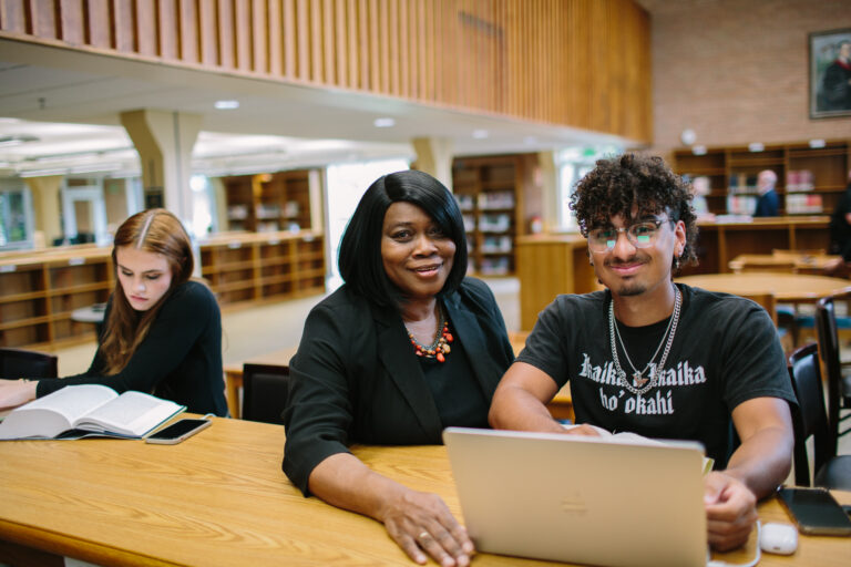 A CIU financial aid advisor and a student work together on a laptop in the CIU library.