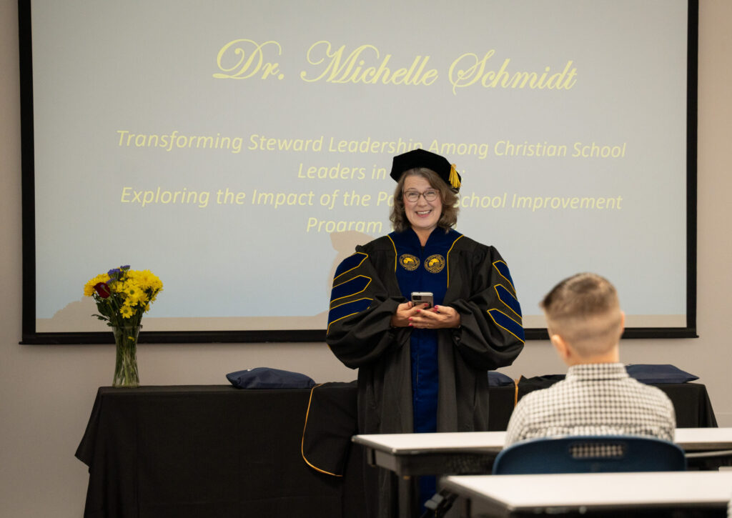 Dr. Michelle Schmidt in doctoral regalia at her PhD hooding ceremony at Columbia International University