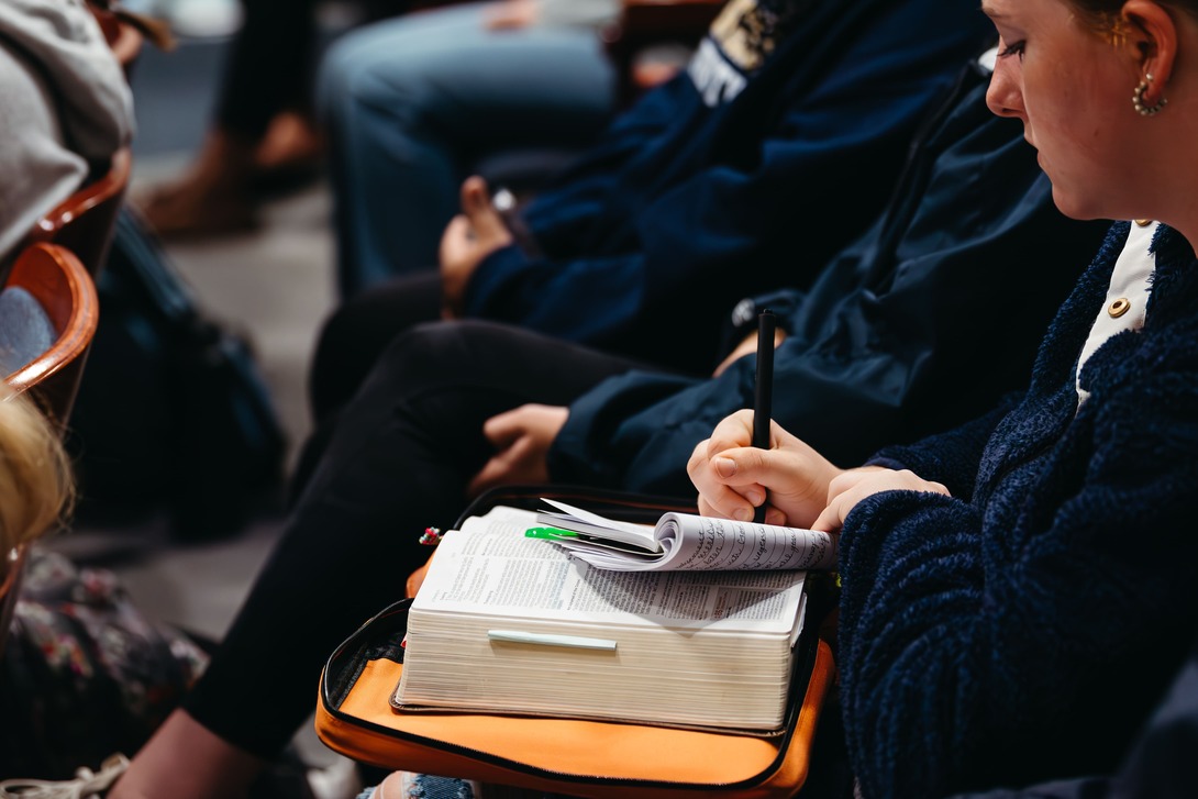 Student in chapel with Bible open