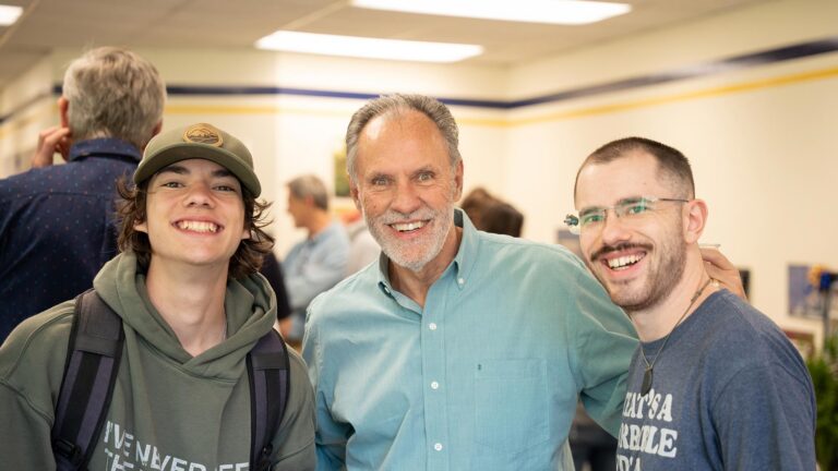 Dr. Ken Rife poses with students a retirement party