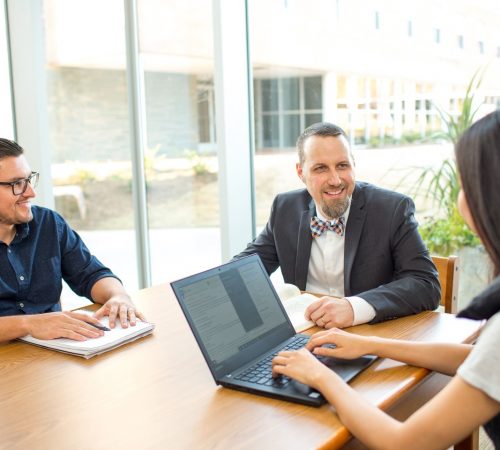 Business students with laptops studying